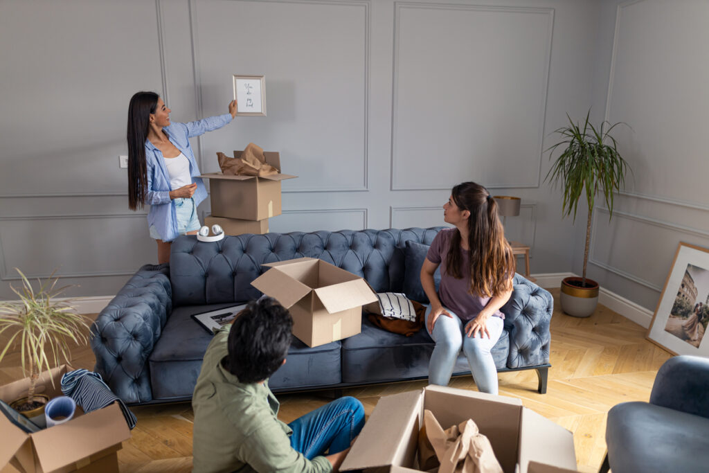 smiling girl showing her friends how she will decorate their new apartment.