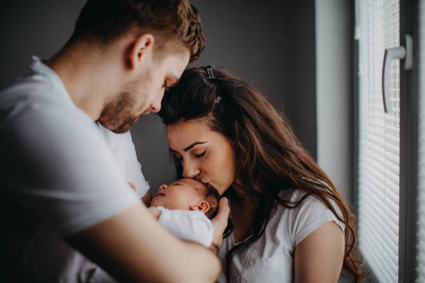 smiling young parents with their baby girl at home