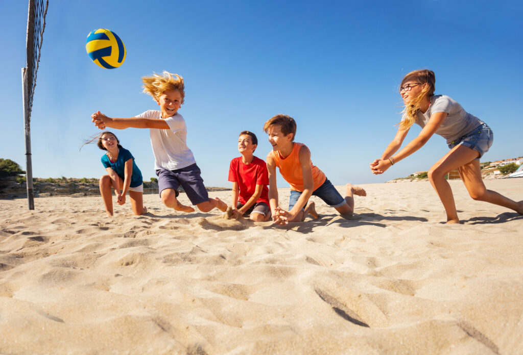 boy making bump pass during beach volleyball game