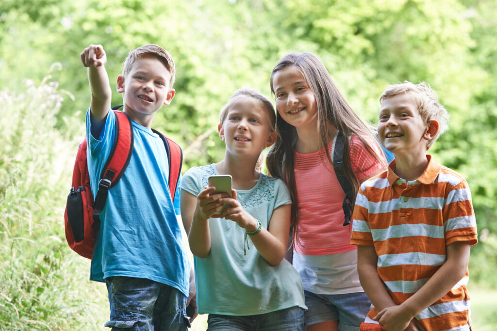 group of children geocaching in woods