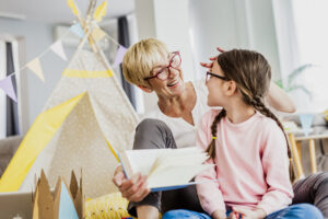 a grandmother is reading a book to the granddaughter