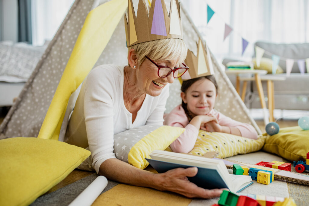 a grandmother is reading a book to the granddaughter