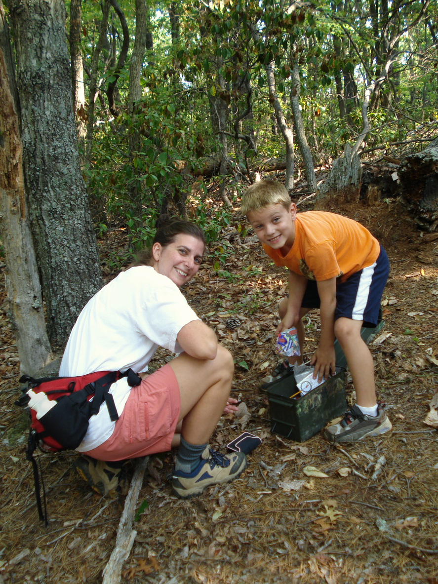 boy & mother (family) geocaching in the woods.
