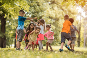 group of small kids having fun while playing in nature.