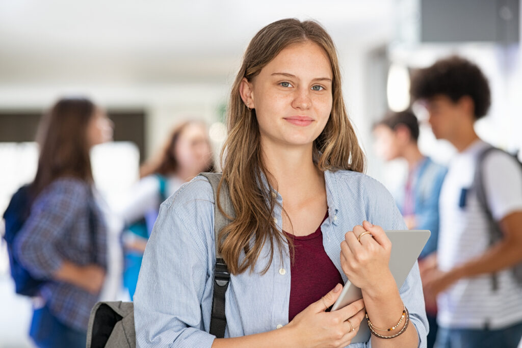 school girl holding digital tablet in college