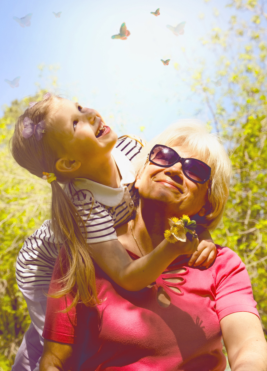 loving cute granddaughter hugging her grandmother. happy family. having good times with grandparent outdoors. smiling, happy, enjoy