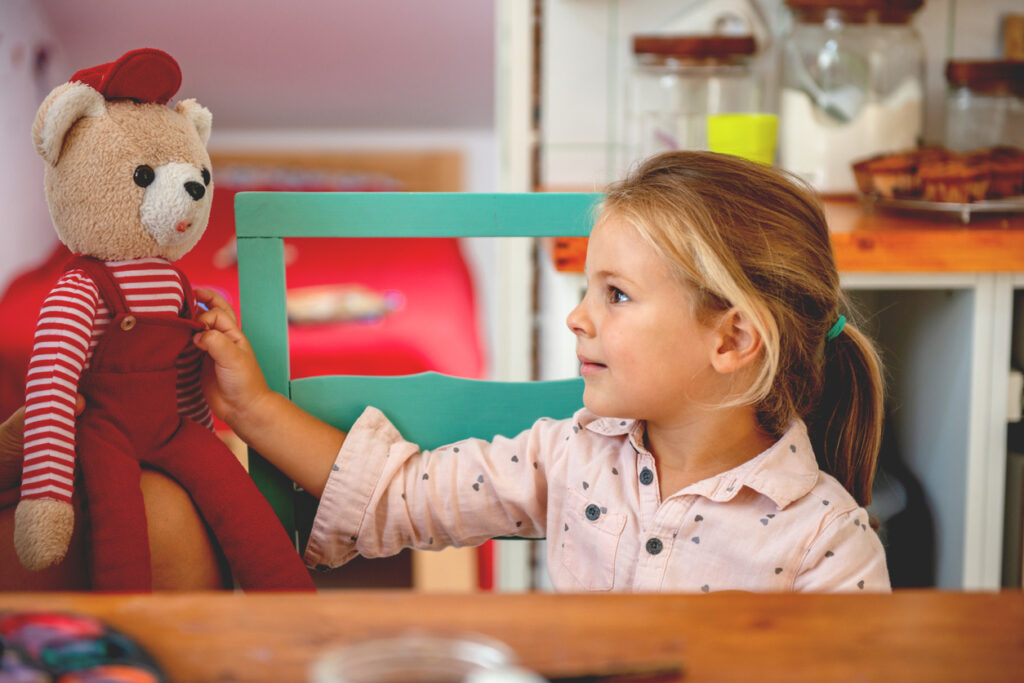 little girl looking at her favorite tedy bear