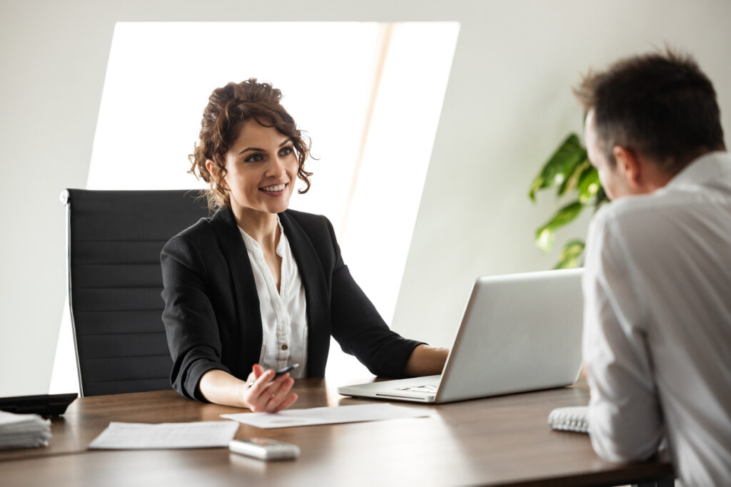 portrait of a smiling businesswoman talking to a client.