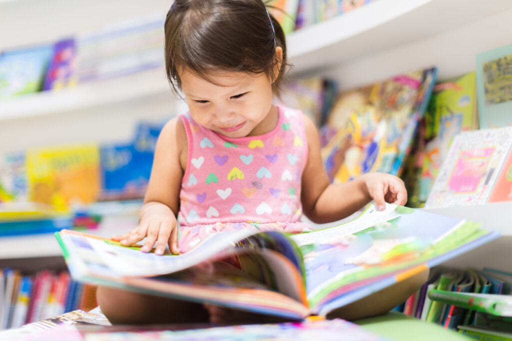 little girl reading a book. education.
