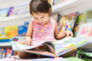 little girl reading a book. education.