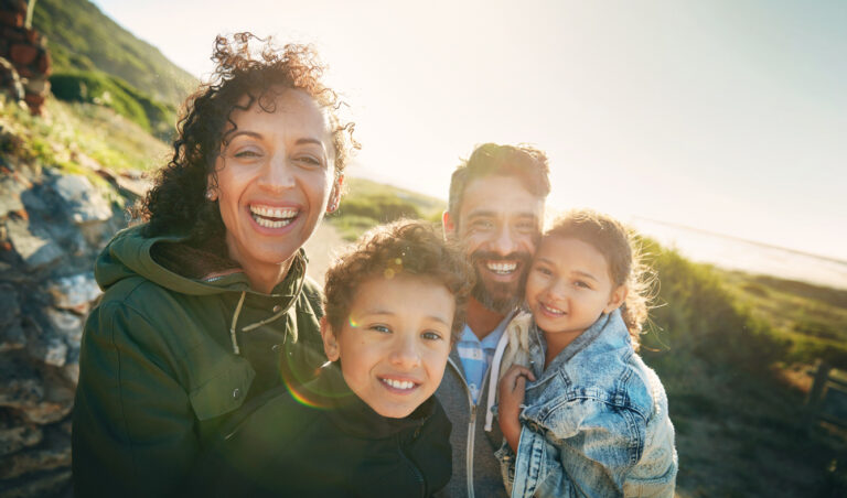 holiday, mountain and portrait of family with smile, nature and outdoor bonding together on travel adventure. mom, dad and children on summer vacation with hiking, happy face and sunshine on hill