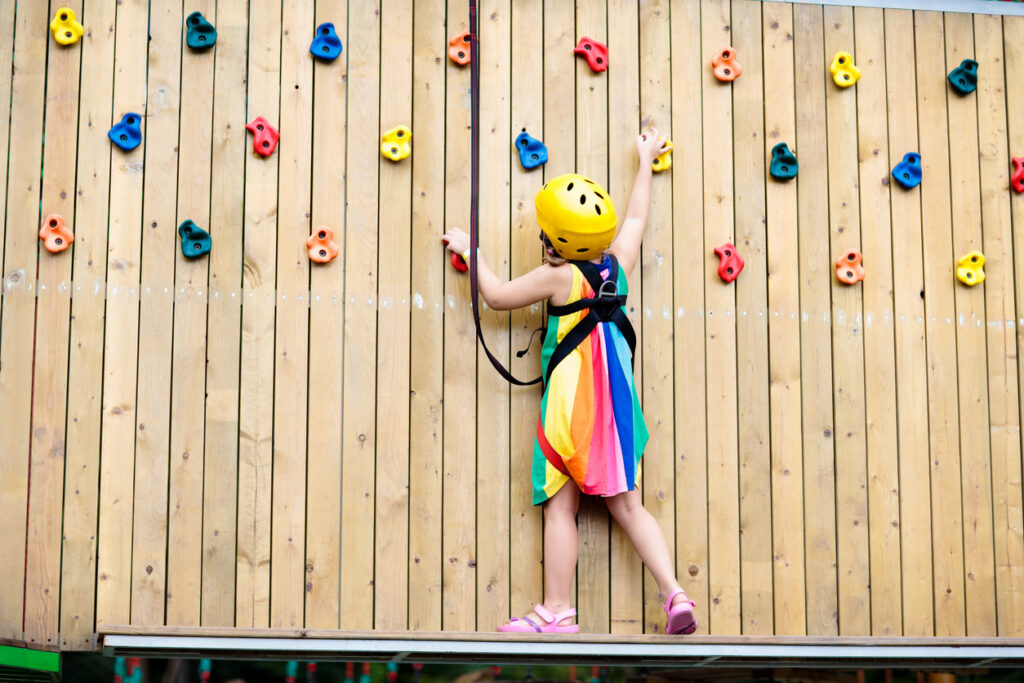 child in adventure park. kids climbing rope trail.