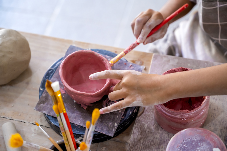 kids making a craft of a porcelain mug from wet clay