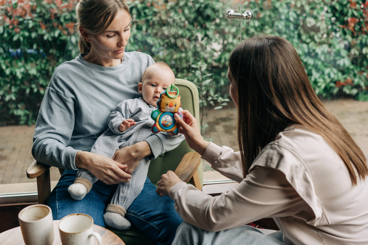 two young caucasian women are sitting in a cafe with a child.